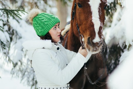 beautiful girl and horse in the winter forestの写真素材