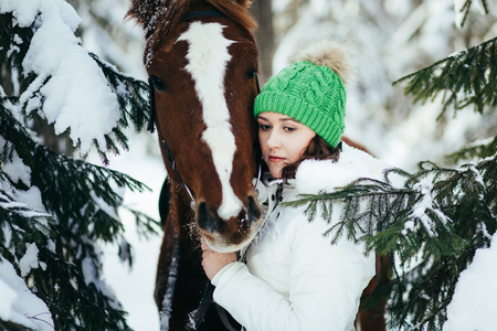 beautiful girl and horse in the winter forestの写真素材