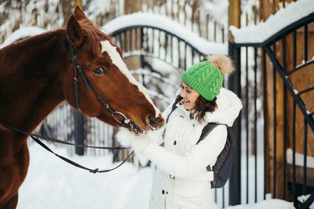 beautiful girl and horse in the winter forestの写真素材