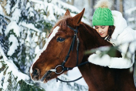beautiful girl and horse in the winter forestの写真素材