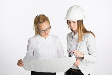 Two happy business women talking and signing documentの写真素材