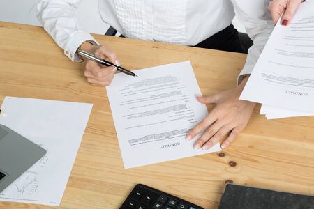 Close-up portrait of young businesswoman sitting at office while fill the application form on job...