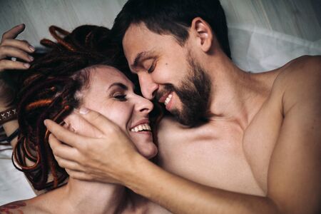 Young positive hipster couple without any clothes hugging each other. The girl has dreadlocks. Love story concept.の写真素材