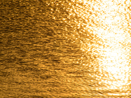 Golden wavelets on the surface of a waterの写真素材