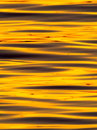 Wavelets on the surface of sunset lake の写真素材