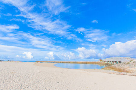 Sandy beach with a bridge in Okinawaの写真素材