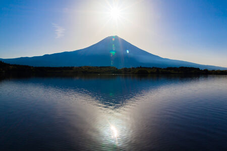 Sun shine and inverted Mount Fuji reflected in Lake Tanukiko の写真素材
