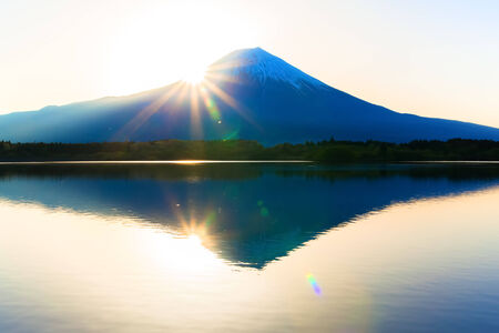 Sun shine and inverted Mount Fuji reflected in Lake Tanukiko の写真素材