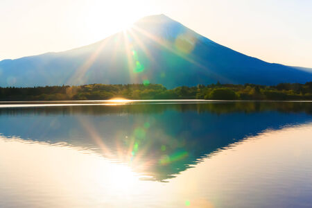 Sun shine and inverted Mount Fuji reflected in Lake Tanukiko の写真素材