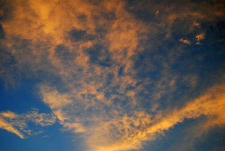 Deep blue sky with orange cloudsの写真素材