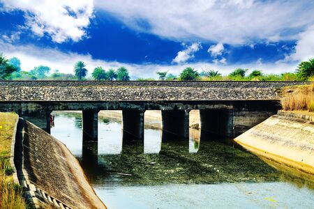 Railway bridge in a canal with clorful blue skyの写真素材