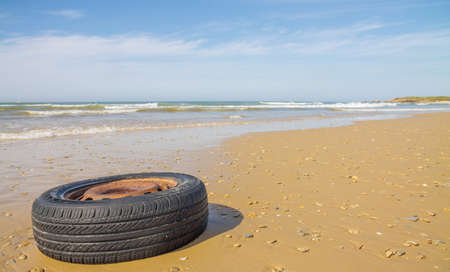 old wheel from the car on the beachの写真素材