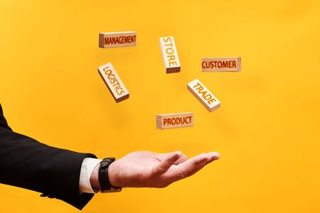 private business development concept, a man throws up wooden blocks with the inscriptions management, store, customer, logistics, product, tradeの写真素材