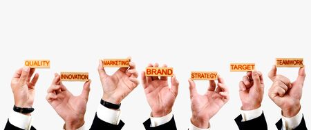 brand concept, hands hold wooden blocks with the inscriptions marketing, innovation, quality, strategy, teamwork, targetの写真素材