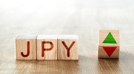 wooden blocks with the inscription jpy and a block symbolizing the rise and fall of financial marketsの写真素材