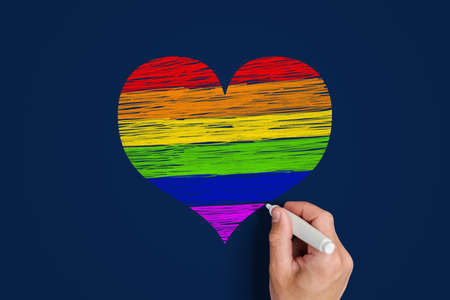LGBT community concept. man draws a heart painted in lgbt community flag colorsの写真素材