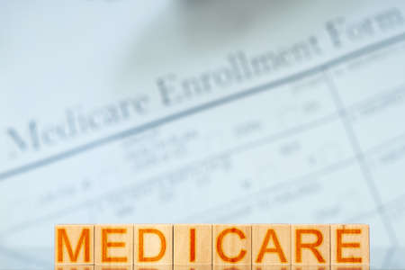 medicare concept. wooden blocks with the inscription on the background with Medicare enrollment formの写真素材