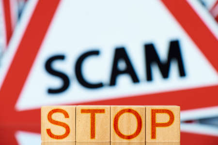 stop scam. wooden blocks with stop inscription and scam sign on background