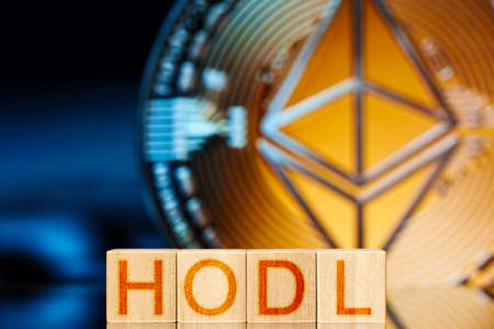 hodl eth concept. wooden blocks with hodl lettering and ethereum cryptocurrency on background