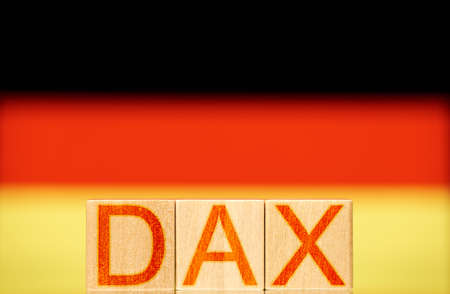 dax index concept. wooden blocks with the word dax on the background of the national flag of germanyの写真素材