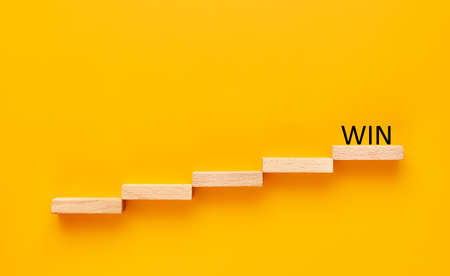 win. wooden block staircase with win sign on top