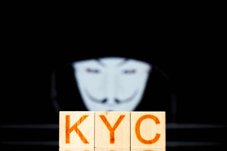 kyc. wooden cubes with the inscription kyc on a background with a man in a maskの写真素材