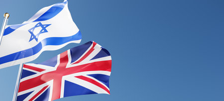 United Kingdom and Israel flags fluttering in the wind against a blue sky mockup with copy space. UK...