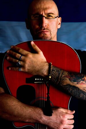 Man with the acoustic guitar on black backgroundの写真素材
