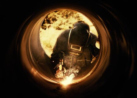 A metalworker welding a metal barrelの写真素材