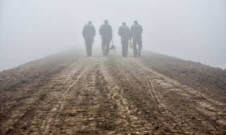 workers walking trail through the fogの写真素材