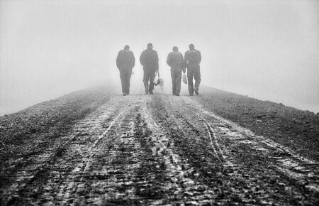 workers walking trail through the fogの写真素材