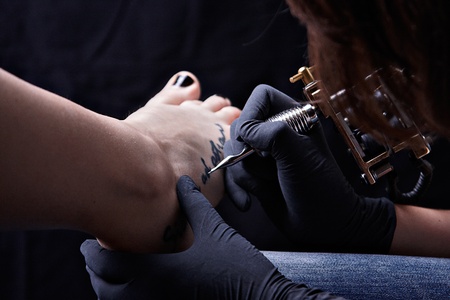 The girl tattooed his footの写真素材