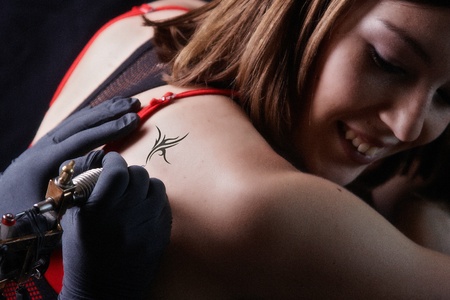 Girl tattoo artist works on the clientの写真素材
