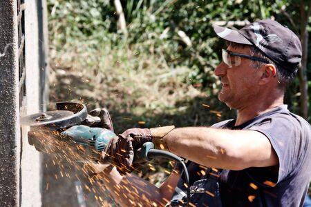 man cutting metal mesh using grinders