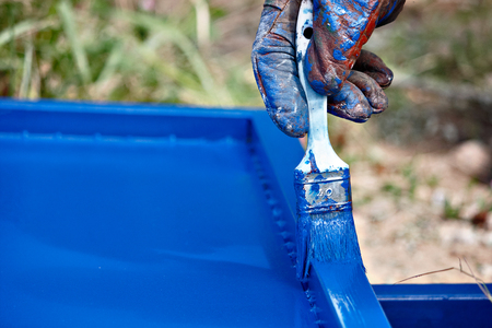 painting metal profiles in blue with a brushの写真素材