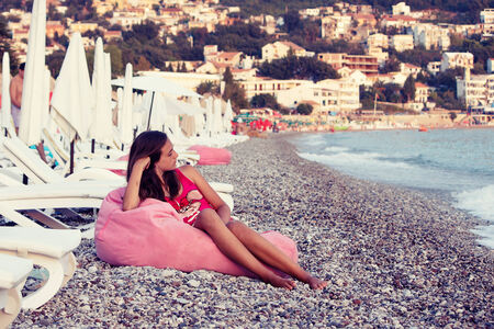 Girl on the sun loungers on the beachの写真素材