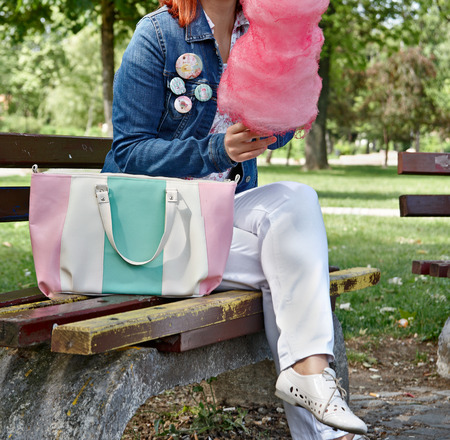 Girl eating cotton candy in the park の写真素材