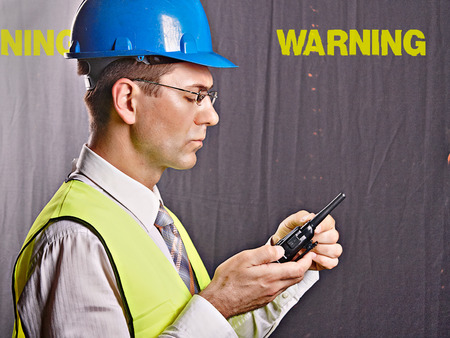 An engineer with a helmet on a construction site communicatesの写真素材