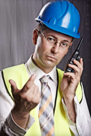 An engineer with a helmet on a construction site communicatesの写真素材
