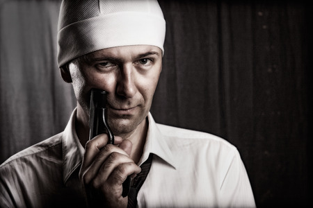 man with a tie holding a gun, focus on eyesの写真素材