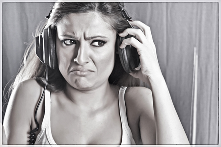The girl listens to bad music on the headphonesの写真素材