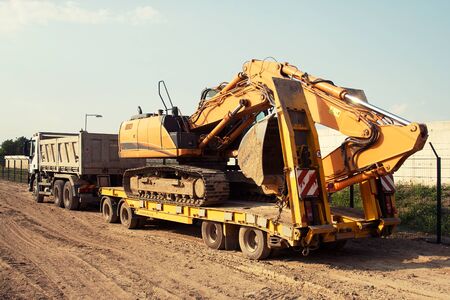 commercial delivery cargo truck with tracked excavator, focus on excavator