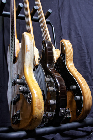Three electric bass guitar standing on a stand