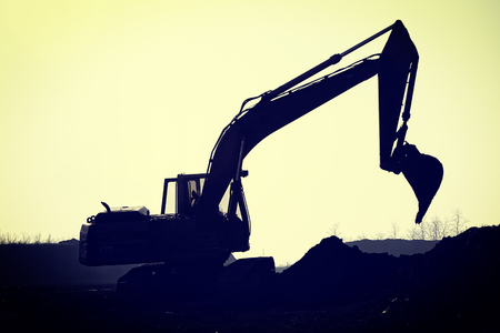 Silhouette excavator on construction siteの写真素材