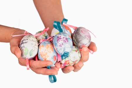 Colorful easter eggs in a hand, isolated on whiteの写真素材