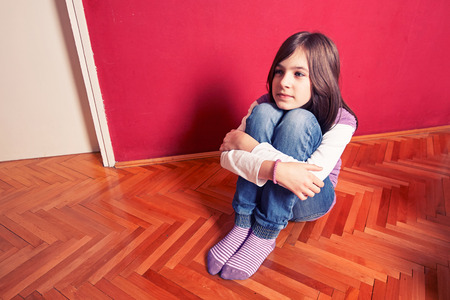 An attractive little girl sitting on the floorの写真素材