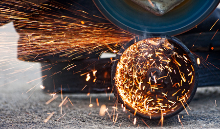 Cutting metal with grinder. Sparks while grinding ironの写真素材