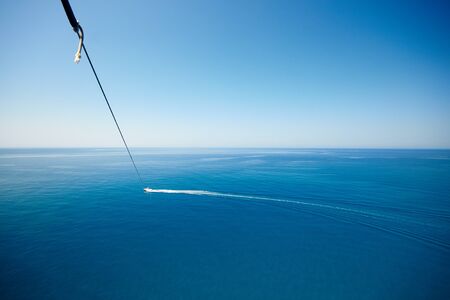 View of feet parasailing with the speed boat in the sea background.の写真素材