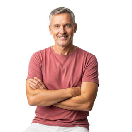 The image features a middle-aged man with gray hair, smiling confidently. He is wearing a red t-shirt and has his arms crossed. The background is plain white, putting the focus entirely on him. His expression is friendly and approachable, suggesting a sense of contentment and self-assurance.の素材