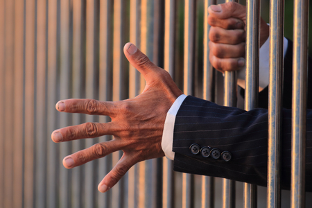 hand of business man in jail with copyspace background.の写真素材